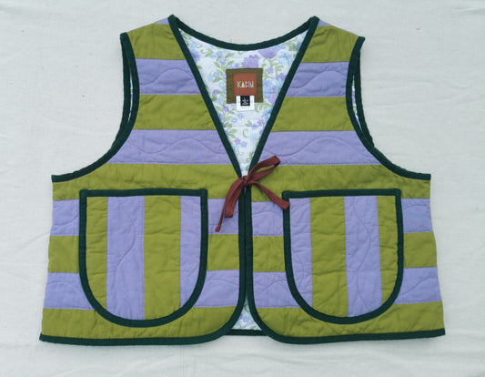 A handmade quilted vest by KABIN NZ with horizontal olive green and lavender purple stripes, dark green trim, two front patch pockets, and a burgundy tie closure, laid flat on a white background.