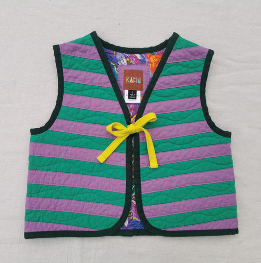 A handmade quilted children's vest by KABIN with horizontal purple and green stripes, dark green trim, and a yellow tie at the centre front. 